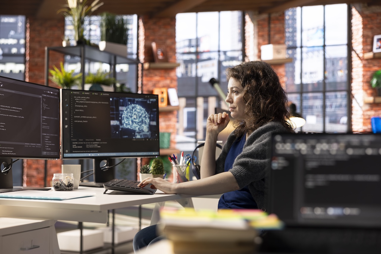 Professionista al computer che lavora con strumenti di Intelligenza Artificiale in un ambiente tech moderno